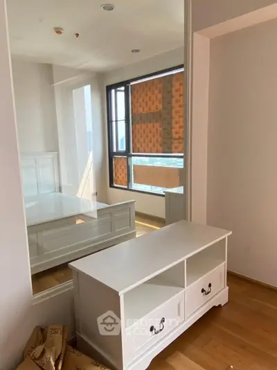 Spacious bedroom with large mirror and elegant white furniture