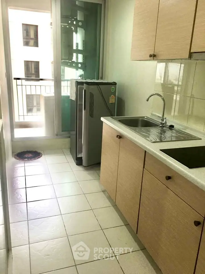 Spacious kitchen with modern appliances and balcony access in a bright apartment.