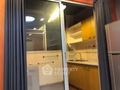 Cozy kitchen with sliding glass door and modern appliances in a stylish apartment.