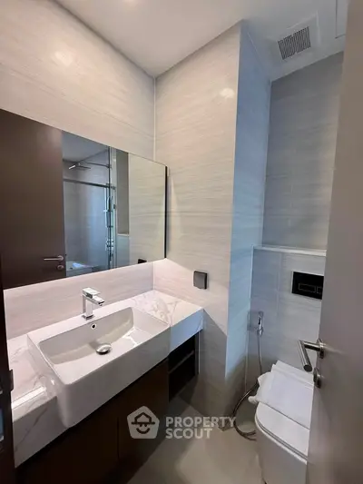 Modern bathroom with sleek design, featuring a stylish sink and contemporary fixtures.