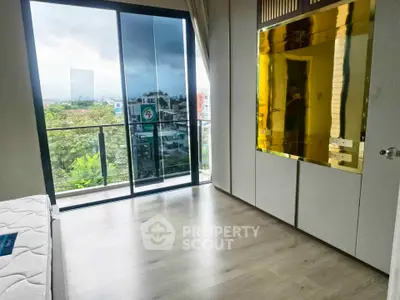 Modern bedroom with large window and balcony offering stunning city view