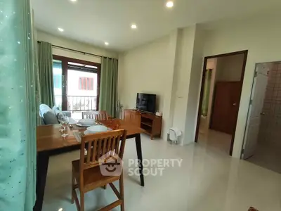 Bright and cozy living room with dining area and TV, perfect for relaxation.