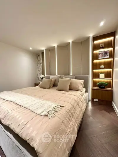 Luxurious bedroom with elegant lighting and plush bedding in modern apartment