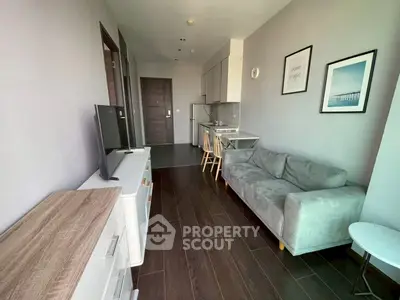 Modern living room with sleek furniture and open kitchen layout in a stylish apartment.