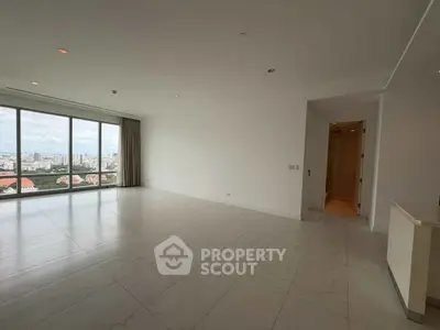 Spacious modern living room with large windows offering stunning city views.