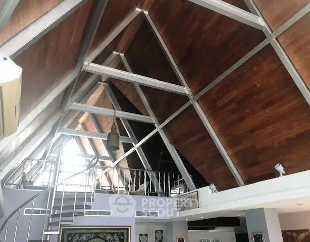 Stunning modern loft with high wooden ceilings and spiral staircase, perfect for stylish urban living.