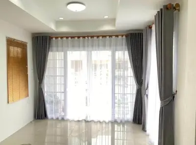 Bright living room with large windows and elegant curtains