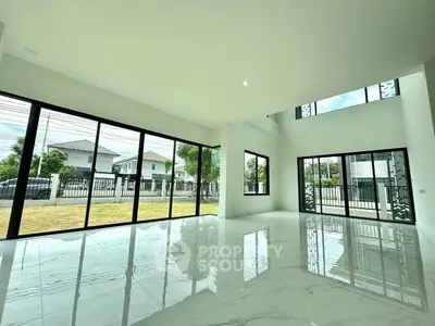 Spacious modern living room with large windows and glossy marble floors.