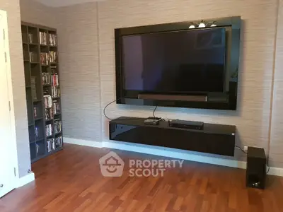 Modern living room with wall-mounted TV and sleek wooden flooring