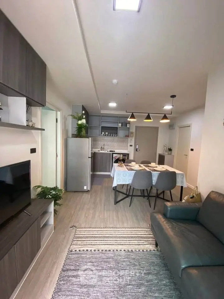 Modern open-plan living room and kitchen with stylish decor and dining area.