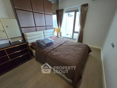 Modern bedroom with stylish decor and large windows offering city views, perfect for urban living.