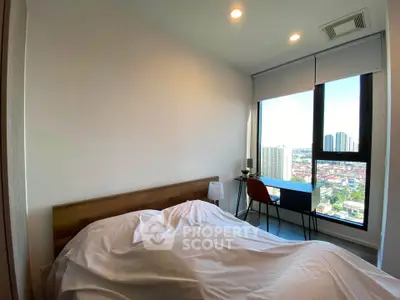 Modern bedroom with city view, featuring a cozy bed and stylish desk setup.