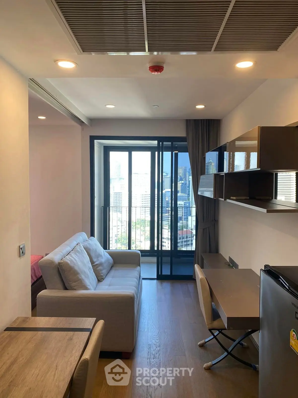 Modern studio apartment with city view, featuring cozy living area and compact kitchen.