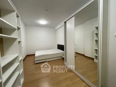 Spacious bedroom with wooden flooring and mirrored wardrobe