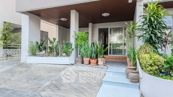 Charming entrance with lush greenery and modern design, perfect for welcoming guests.