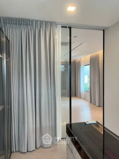 Elegant modern interior with floor-to-ceiling curtains and sleek design elements.