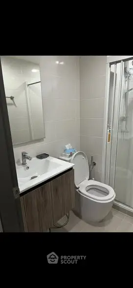 Modern bathroom with sleek fixtures and glass shower enclosure.