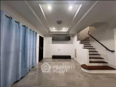 Spacious modern living room with elegant staircase and stylish lighting