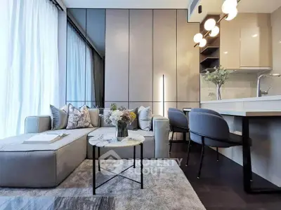 Modern living room with elegant decor and open kitchen layout, featuring stylish furniture and natural light.