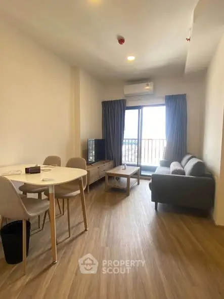 Modern living room with dining area and balcony view in a stylish apartment.