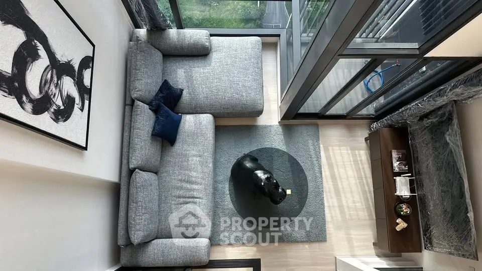 Modern living room with large windows and stylish furniture, offering a cozy and bright atmosphere.