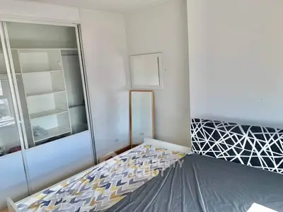 Modern bedroom with stylish bed and built-in wardrobe