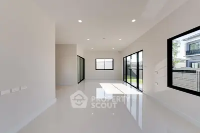 Spacious modern living room with large windows and sleek tile flooring