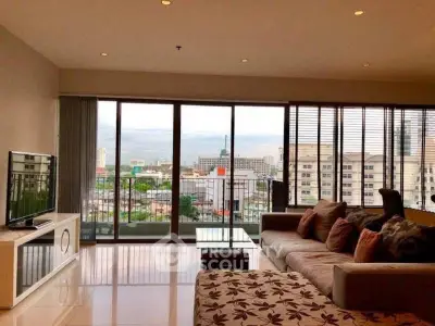 Spacious living room with large windows offering stunning city views and modern furnishings.