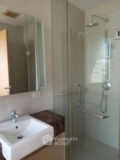 Modern bathroom with glass shower enclosure and sleek sink design