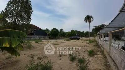 Spacious vacant land with potential for development, surrounded by greenery and a serene environment.