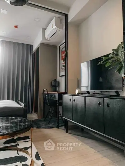 Modern living room with sleek furniture and stylish decor, featuring a TV and air conditioning.