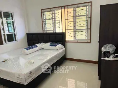 Spacious bedroom with modern furnishings and large window for natural light.