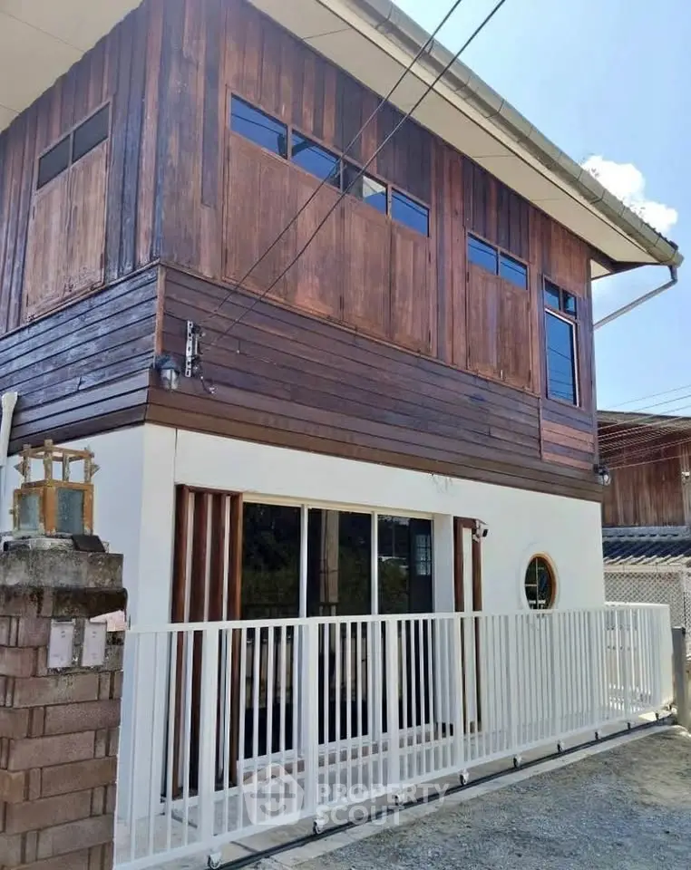 Charming wooden exterior house with modern white fence and large windows