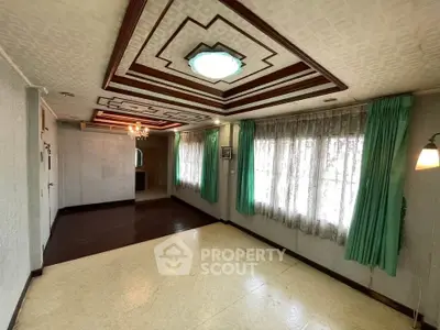 Spacious living room with unique ceiling design and large windows