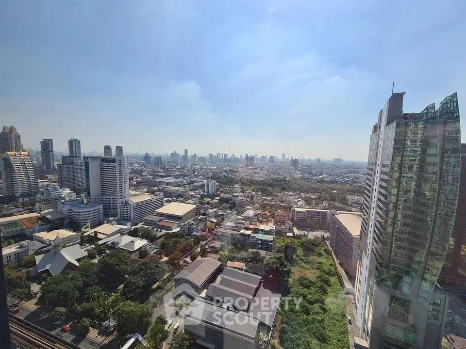 Stunning cityscape view from high-rise building showcasing urban skyline and greenery.