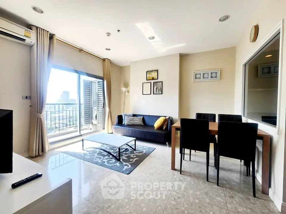 Spacious living room with modern decor and balcony view in a high-rise apartment.