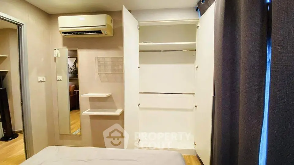 Cozy bedroom with open wardrobe and air conditioning unit