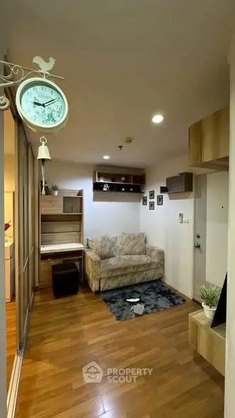Cozy living room with wooden flooring and modern decor, featuring a comfortable sofa and stylish shelving.