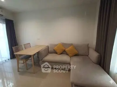Cozy living room with modern sofa and dining table, perfect for relaxation and entertaining.