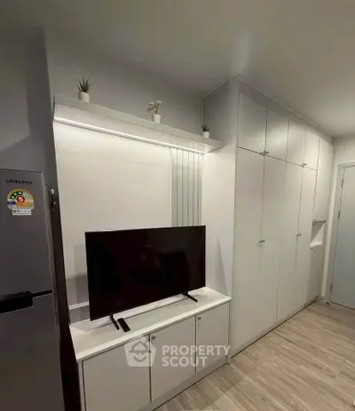 Modern living room with sleek TV unit and ample storage cabinets, perfect for urban living.