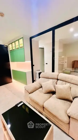 Modern living room with plush sofa and sleek glass partition in stylish apartment.