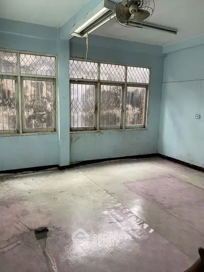 Spacious room with large windows and natural light, ideal for renovation or creative projects.