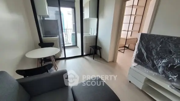 Modern compact living room with balcony access and sleek furniture