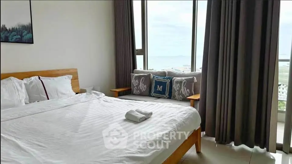 Spacious bedroom with ocean view and modern decor in luxury apartment