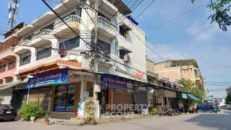 Charming multi-story building with street-level shops in vibrant urban setting.