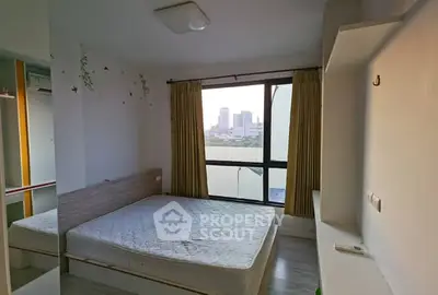Cozy bedroom with city view, featuring a large window and minimalist decor.
