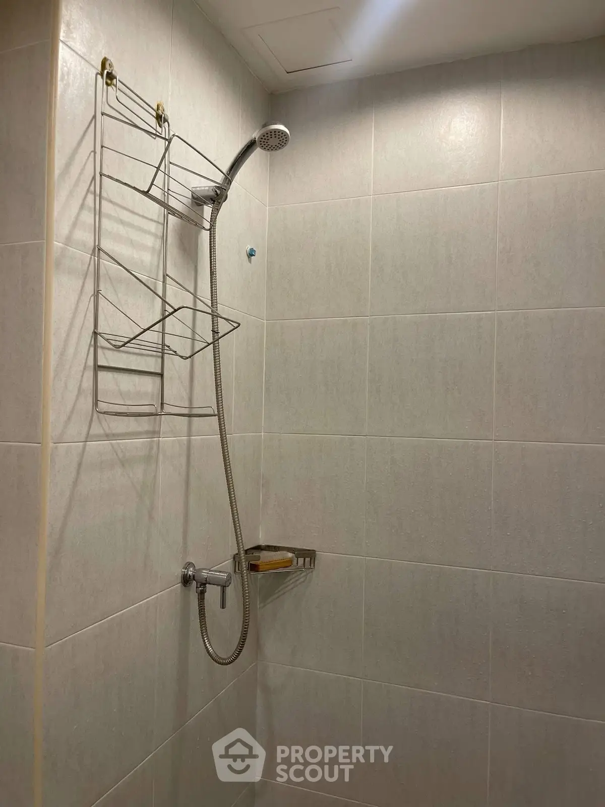 Modern bathroom shower area with sleek tile design and chrome fixtures.