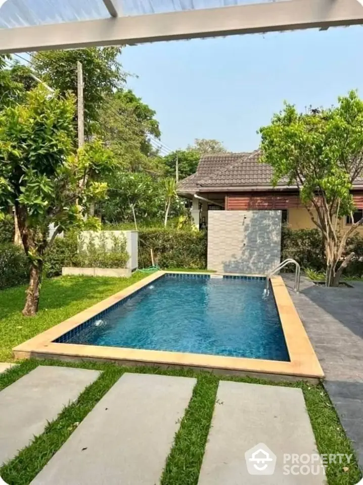 Charming backyard with a pristine swimming pool and lush greenery, perfect for relaxation and outdoor enjoyment.