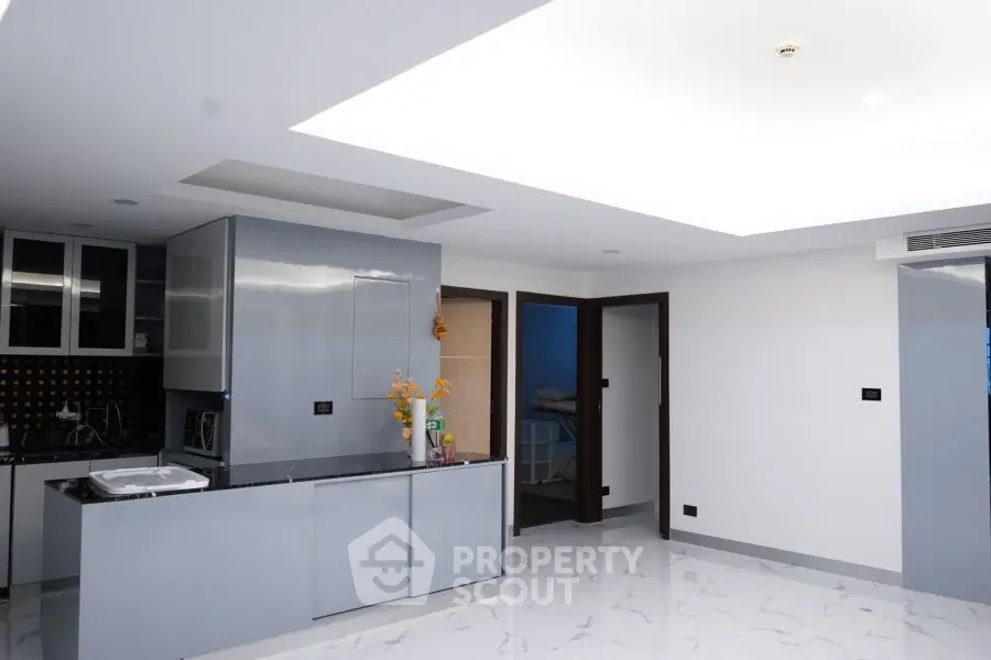 Modern kitchen with sleek cabinets and marble flooring in a contemporary apartment.