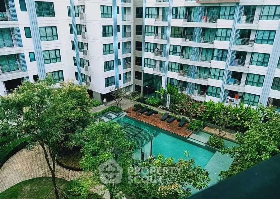 Modern apartment complex with pool and lush greenery view